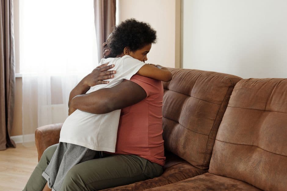 Father and son sharing a warm embrace on the sofa, expressing love and family togetherness.